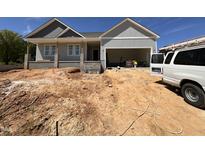 New construction home with a two-car garage and landscaping ready for the new owner at 221 Tee Dr, Selma, NC 27576