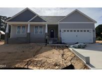 Charming single-Gathering home with gray siding, a two-car garage, and well-manicured front yard at 221 Tee Dr, Selma, NC 27576