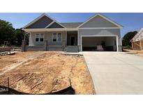Charming single-story home with a two-car garage and covered front porch at 221 Tee Dr, Selma, NC 27576