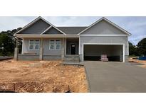 New construction home featuring a gray exterior, covered porch, and attached two-car garage at 221 Tee Dr, Selma, NC 27576