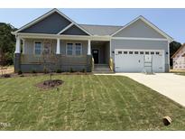 Beautiful craftsman home with a lush lawn, covered porch and an attached two car garage at 221 Tee Dr, Selma, NC 27576