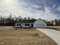 Charming single-story home featuring a classic white facade and a two-car garage at 225 Phil Jack Rd, Dunn, NC 28334