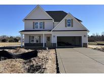 New two-story home featuring a two car garage, stone accents, and newly poured driveway at 253 Trescott St, Smithfield, NC 27577