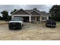 A single-Gathering home featuring a spacious garage, complemented by a black pickup truck at 28 Bailey-Boykin Rd, Selma, NC 27576