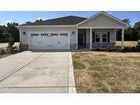 Charming single-story home with a two-car garage, stone accents, and a well-manicured lawn, located in a quiet neighborhood at 282 Trescott St, Smithfield, NC 27577