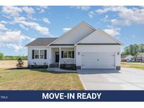 Charming one-story home features a white exterior, black shutters, and an attached two-car garage at 30 Tee Dr, Selma, NC 27576
