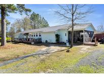This property features a lengthy, single-story design, a gravel driveway, and a charming screened porch at 309 14Th St, Butner, NC 27509