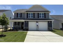 Charming two-story home with a gray exterior, a two-car garage, and a well-manicured lawn at 33 W Emily Gardens Dr, Selma, NC 27576