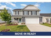 Charming two-story home with gray siding, black shutters, and a welcoming front porch at 33 W Emily Gardens Dr, Selma, NC 27576