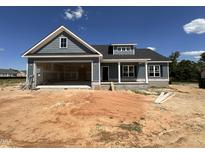 New home with blue siding, stone foundation, open garage and unfinished yard at 40 Bailey-Boykin Rd, Selma, NC 27576