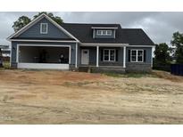 Charming blue home with gray stone accents, a garage, and covered porch for a modern and inviting feel at 40 Bailey-Boykin Rd, Selma, NC 27576