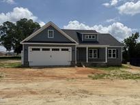 New construction home featuring a two-car garage and stone-accented columns on the front porch at 40 Bailey-Boykin Rd, Selma, NC 27576