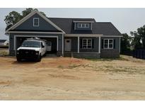 Charming home featuring blue siding, stone accents, attached garage, and a welcoming front porch at 40 Bailey-Boykin Rd, Selma, NC 27576