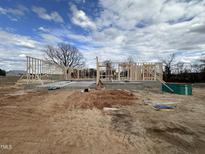 New construction shows the initial framing of a home with the foundation and framing in place under a cloudy blue sky at 40 Bailey-Boykin Rd, Selma, NC 27576