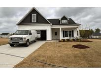 Charming two-story home with black and white siding, a front yard, and a driveway with a white van at 40 Tuskeegee Dr, Smithfield, NC 27577