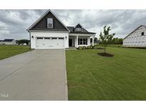Charming single-Gathering home featuring a well-maintained lawn and an attached two-car garage at 40 Tuskeegee Dr, Smithfield, NC 27577