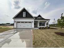 Charming new construction home featuring a two-car garage, black accents, and a well-manicured lawn at 40 Tuskeegee Dr, Smithfield, NC 27577
