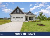 Charming home with white siding, black accents, and a well-manicured lawn at 40 Tuskeegee Dr, Smithfield, NC 27577