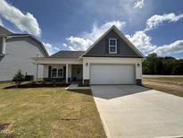 Charming one-story home featuring a two-car garage, stylish gray accents, and a well-manicured front lawn at 41 W Emily Gardens Dr, Selma, NC 27576