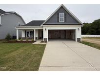Charming home with gray and white siding, a spacious driveway, and an attached two-car garage at 41 W Emily Gardens Dr, Selma, NC 27576