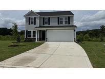 Charming two-story home features a two-car garage and a well-manicured front yard at 43 Chloe Ct, Selma, NC 27576