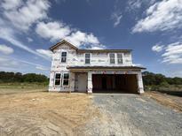 Two-story home under construction with visible framework, windows, and builder's wrap against a partly cloudy sky at 43 Chloe Ct, Selma, NC 27577