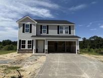 Two story home featuring black shutters, light gray siding, and a large two car garage at 43 Chloe Ct, Selma, NC 27577