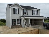 New two-story home featuring gray siding, black shutters, stone accents, and an attached two-car garage at 43 Chloe Ct, Selma, NC 27577