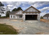 An exterior view of a single story home with a two car garage still in the construction phase on a cloudy day at 47 Royal Ave, Selma, NC 27576