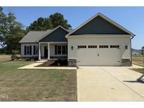 Charming home featuring a two-car garage, stylish green and white siding, and a well-maintained front yard at 47 Royal Ave, Selma, NC 27576