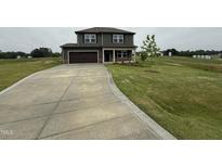 A charming two-story home with an attached garage and long driveway at 48 Silver Ct, Smithfield, NC 27577