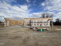 View of a construction site with the frame of the house under a cloudy sky at 56 Bailey-Boykin Rd, Selma, NC 27576