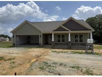 A charming one-story home with a light green exterior, covered porch, and an attached two-car garage at 56 Bailey-Boykin Rd, Selma, NC 27576