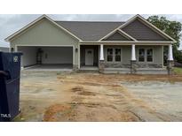 Charming exterior view of home showcasing covered porch, gray shake accents, with a spacious two car garage at 56 Bailey-Boykin Rd, Selma, NC 27576