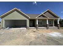 New construction home exterior with stone accents, covered porch, two car garage, and green siding at 56 Bailey-Boykin Rd, Selma, NC 27576