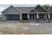 Charming single-story home with a two-car garage, inviting front porch with stone accents, and a neutral color palette at 56 Bailey-Boykin Rd, Selma, NC 27576