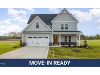 Charming two-story home with a two-car garage, complemented by a well-manicured lawn at 65 Barony Ln, Smithfield, NC 27577
