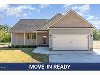Charming single-story home with a two-car garage, well-manicured lawn, and inviting curb appeal at 68 Tee Dr, Selma, NC 27576