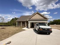Charming single-story home with a two-car garage and manicured lawn on a sunny day at 68 Tee Dr, Selma, NC 27576