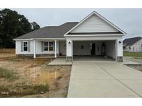 New construction home features a two-car garage, stone accents and light gray shutters at 71 Royal Ave, Selma, NC 27576