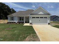 Charming single Gathering home with a 2 car garage, beautifully landscaped yard and covered front porch at 71 Royal Ave, Selma, NC 27576