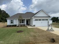 Charming single-story home featuring a two-car garage and well-manicured lawn at 71 Royal Ave, Selma, NC 27576