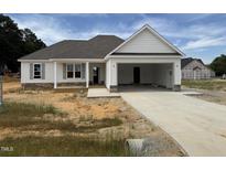 New construction featuring a two-car garage, stone accents, and a covered porch at 71 Royal Ave, Selma, NC 27576