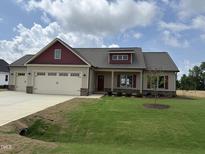 Charming single-Gathering home boasts a two-car garage, beautiful lawn and appealing exterior with red accents at 76 Royal Ave, Selma, NC 27576