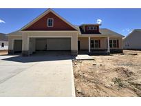 New construction featuring a 2-car garage, covered porch and manicured lawn at 76 Royal Ave, Selma, NC 27576