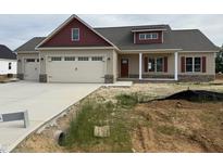 A charming home featuring a two-car garage, red accents, and a partially landscaped front yard at 76 Royal Ave, Selma, NC 27576