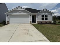 Charming single-story home featuring a two-car garage and well-maintained lawn at 8 W Emily Gardens Dr, Selma, NC 27576