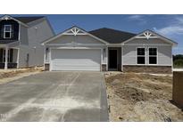Charming single-story home featuring a two-car garage and stone accents at 8 W Emily Gardens Dr, Selma, NC 27577
