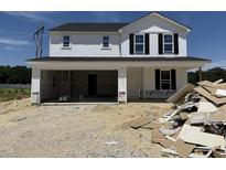 New construction home with white siding, black shutters, and an attached two-car garage at 82 W Emily Gardens Dr, Selma, NC 27577