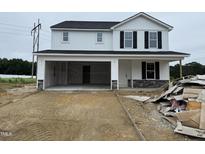 Charming two-story home with a convenient attached two-car garage and unfinished landscape at 82 W Emily Gardens Dr, Selma, NC 27577